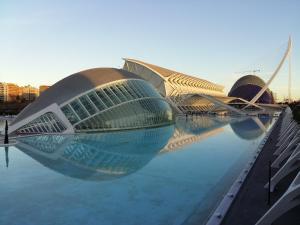 a building with its reflection in the water at Dorado Cabanyal - Luxury Beachside Charm in Valencia