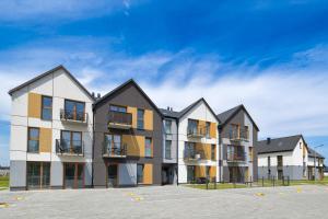 a row of apartment buildings in a parking lot at Jasmine by Housine in Zator