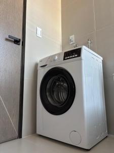 a white washing machine in a room with a door at Aura Exclusive - Achumani in La Paz