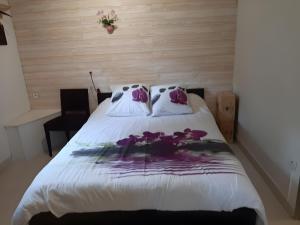 a bedroom with a bed with purple flowers on it at Chambre D'hôtes Indépendante in Pessac