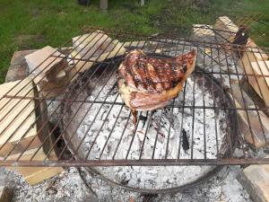a piece of meat is cooking on a grill at Chambre D'hôtes Indépendante in Pessac