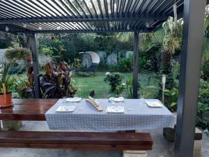 a table under a pergola in a garden at Chambre D'hôtes Indépendante in Pessac