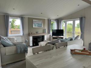 a living room with a couch and a tv at Edmonton Lodge in Clitheroe