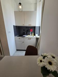 a kitchen with a table with a vase of flowers on it at Studio Apartments - Pula city center in Pula