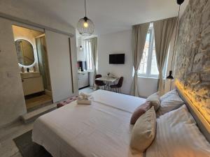 a bedroom with a large white bed and a table at Studio Apartments - Pula city center in Pula