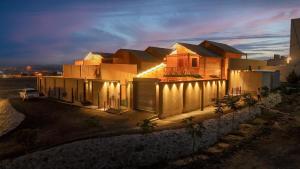 a house with lights on the side of it at night at اكواخ مشارف ابها in Mahlal