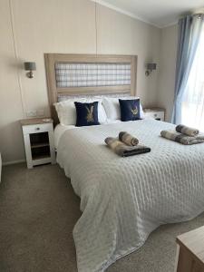 a bedroom with a large white bed with two pillows on it at Edmonton Lodge in Clitheroe