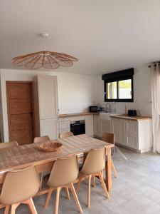a kitchen with a large wooden table and chairs at Gite Ô’Violetis in Domvast +10 photos
