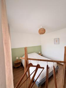 a bedroom with a bed and a chair at Gite Ô’Violetis in Domvast