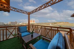 a balcony with a table and chairs and a view of the ocean at اكواخ مشارف ابها in Mahlal +9 photos