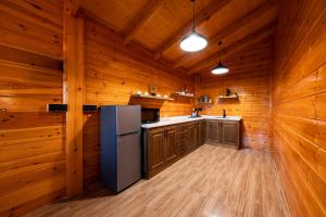 a kitchen with wooden walls and a refrigerator at اكواخ مشارف ابها in Mahlal