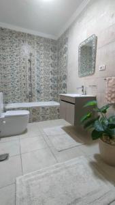 a bathroom with a tub and a toilet and a sink at 378 Pyramids apartment in Nazlet el-Sîsi +34 photos