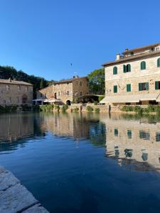 a body of water with buildings in the background at Window to Bagno Vignoni in Bagno Vignoni