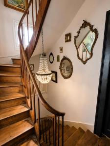 a chandelier hangs over the wooden stairs of a house at La Cour Du Puits Chambre Rooibos in Cormeilles +1 photo