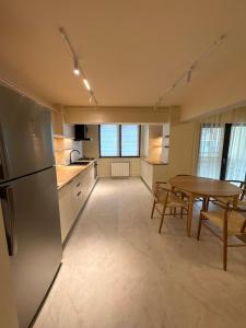 a kitchen and dining room with a table and a refrigerator at City View Apartment in Râmnicu Vâlcea