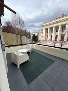 a balcony with two chairs and a table on a building at City View Apartment in Râmnicu Vâlcea