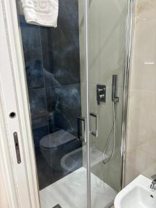 a shower with a glass door next to a toilet at The Superhost - Marekiaro in Crotone