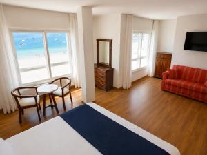 a hotel room with a bedroom with a view of the beach at Hotel Nautilus in Raxó