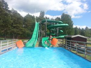 a water slide in a pool with two people on it at Bäcka Holiday Home in Orsa