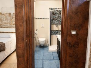 a bathroom with a toilet and a sink in a room at Ulìa - Stone house tra borgo antico e mare in Giovinazzo