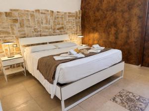 a bedroom with a bed with towels on it at Ulìa - Stone house tra borgo antico e mare in Giovinazzo
