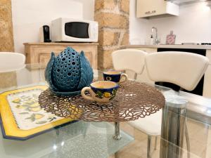 a glass table with two cups on top of it at Ulìa - Stone house tra borgo antico e mare in Giovinazzo