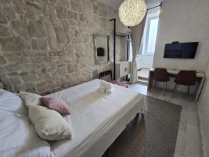 a bedroom with a white bed and a stone wall at Studio Apartments - Pula city center in Pula +14 photos