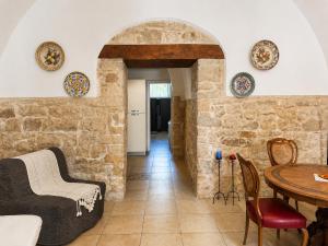 a living room with a table and a stone wall at Ulìa - Stone house tra borgo antico e mare in Giovinazzo +16 photos