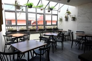 a restaurant with tables and chairs in a room with windows at Casa Tita in Acámbaro