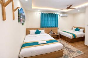 a bedroom with two beds and a blue curtain at Hotel Kusum Palace in Kathmandu