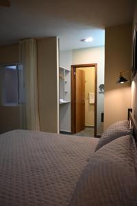 a bedroom with a bed and a door to a bathroom at Casa Tita in Acámbaro