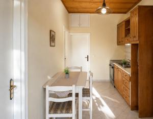 a kitchen with a table and chairs in a room at Nature's Nook Paxos in Vlachopoulátika
