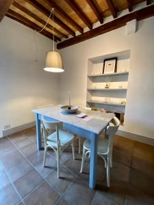 a dining room with a blue table and chairs at Window to Bagno Vignoni in Bagno Vignoni