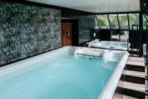 a jacuzzi tub in a room with two sinks at Hostellerie Saint-Louis & Restaurant Pauze - Teritoria in Bollezeele