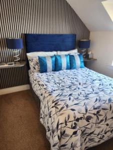 a bedroom with a blue bed with blue pillows at No 27 in Inverness
