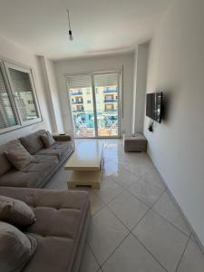 a living room with a couch and a tv at Elois Apartments in Shëngjin