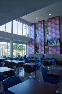 a dining room with tables and blue chairs at Holiday Inn Express Hotel & Suites Hermosillo by IHG in Hermosillo