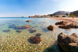 a beach with rocks and the water at George's Studios in Archangelos