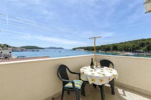 a table and chairs on a balcony with a view of the water at Apartment Mirni by the sea in Prvić Luka