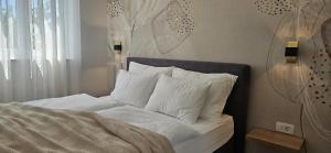 a bed with white sheets and pillows next to a window at APARTMANI SUNSIDE NIN in Nin