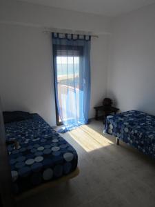 una camera con due letti e una finestra con una porta di Apartment Torralta ad Alvor