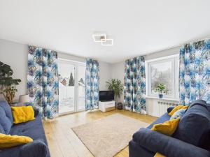 a living room with a blue couch and windows at Radość z Marzeń in Suwałki