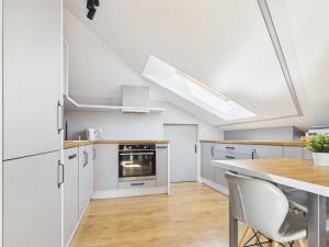 a kitchen with white cabinets and a table with chairs at Radość z Marzeń in Suwałki +14 photos