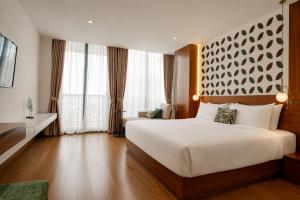 a bedroom with a large bed and a large window at The Scenic Hotel in Phnom Penh