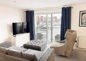 a living room with a couch and chairs and a television at Harbour bliss in Ardrossan