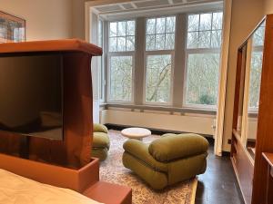 a bedroom with a tv and a chair and windows at La Ruche Oostende in Ostend +65 photos