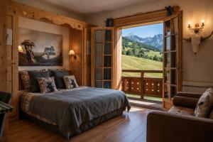 a bedroom with a bed and a large window at Montana Chalet Hôtel & Spa in Le Sauze