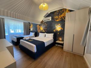 a bedroom with two beds and a wall with a painting at Villa Zen Oasis in Golem