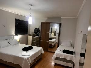 a small bedroom with two beds and a mirror at Smart & Comfort 4 - Ap completo in Campina Grande