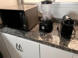 a microwave and a blender sitting on a counter at Smart & Comfort 4 - Ap completo in Campina Grande